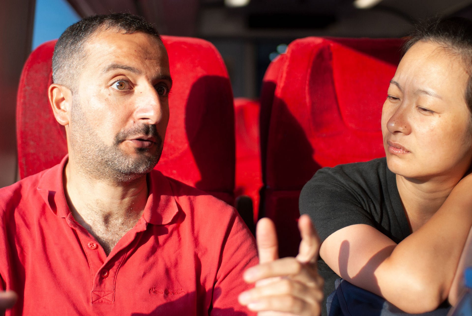 man-and-woman-discussing-an-interesting-topic-in-a-train-flooded-with-sun